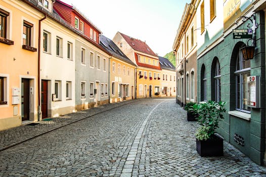 pexels-photo-3651376-3651376 Explore a picturesque cobblestone street in Bad Schandau, Germany, showcasing colorful historic architecture.
