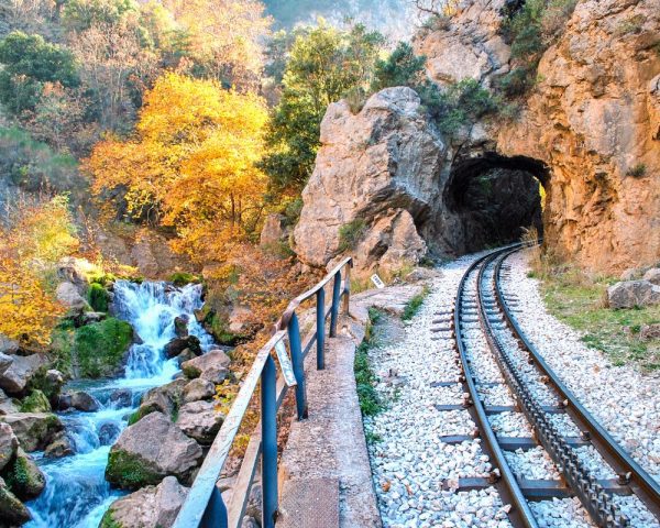 Odontotos Railway, A vibrant fishing boat docked in the serene water, The Peloponnese, Greece Odontotos Railway, A vibrant fishing boat docked in the serene water, The Peloponnese, Greece