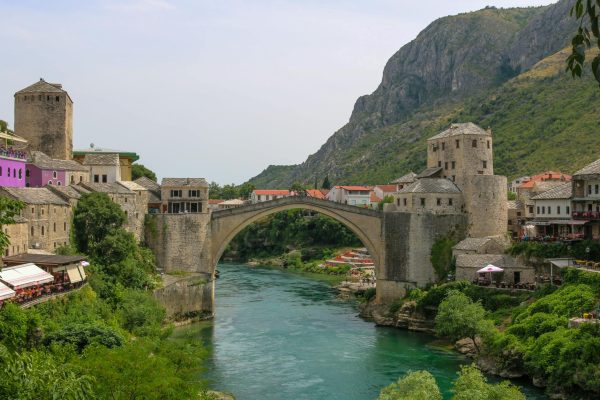 Charming view of Mostar's Old Bridge over the Neretva River, surrounded by medieval buildings. Charming view of Mostar's Old Bridge over the Neretva River, surrounded by medieval buildings.
