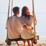 Guy and Girl on a Swing at the beach