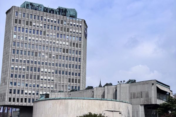 Cold concrete Brutalist buildings surrounding Republic Square in Ljubljana with stark geometric lines and imposing modernist architecture. The large scale structures showcase a striking contrast to the city’s historic Old Town and reflect the bold urban design of the socialist era.