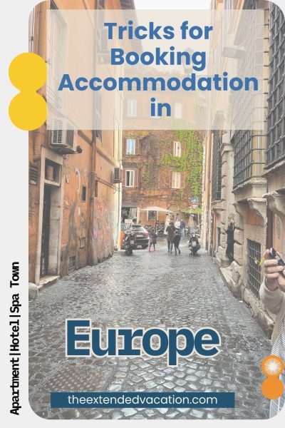 Book With Confidence The Free Cancellation Trick Pinterest graphic with vertical text on the left reading 'Apartment | Hotel | Spa Town,' and 'Tricks for Booking Accommodation in Europe' in blue text at the top. The photo shows a narrow cobblestone alley in Rome lined with weathered orange buildings, an ivy-covered facade in the distance, and people walking past parked scooters. The website theextendedvacation.com is shown at the bottom
